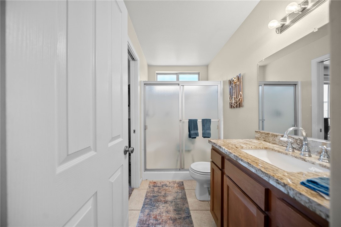 27879 Foxfire Street Menifee, CA 92586 - Photo 25 of 36 a bathroom with a granite countertop sink a mirror and a shower