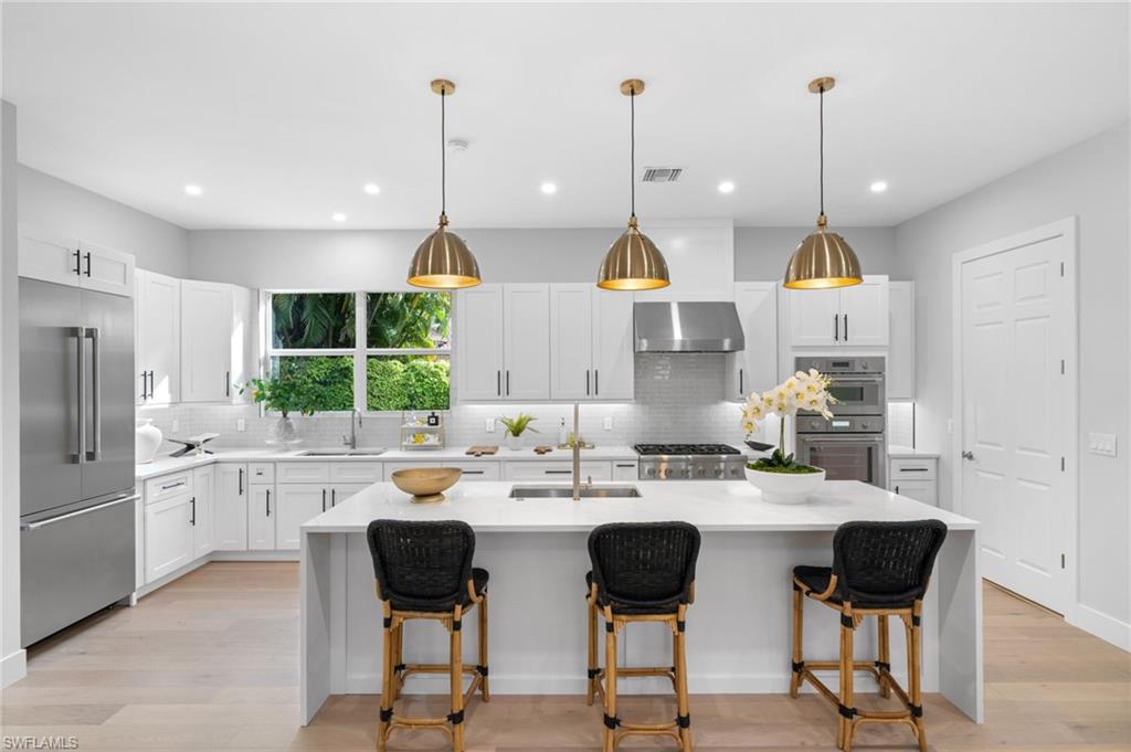 7834 Classics Drive Naples, FL 34113 - Photo 11 of 50 a kitchen with stainless steel appliances kitchen island granite countertop a sink a stove and a refrigerator