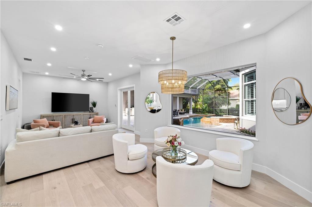 7834 Classics Drive Naples, FL 34113 - Photo 14 of 50 a living room with furniture kitchen view and a wooden floor