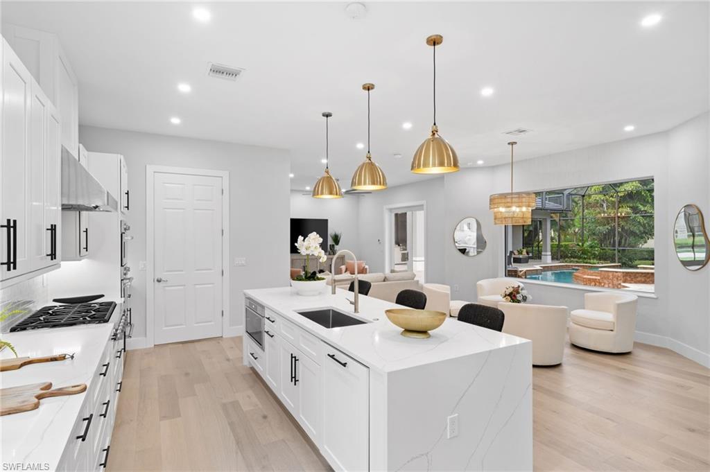 7834 Classics Drive Naples, FL 34113 - Photo 15 of 50 a kitchen that has a lot of cabinets in it
