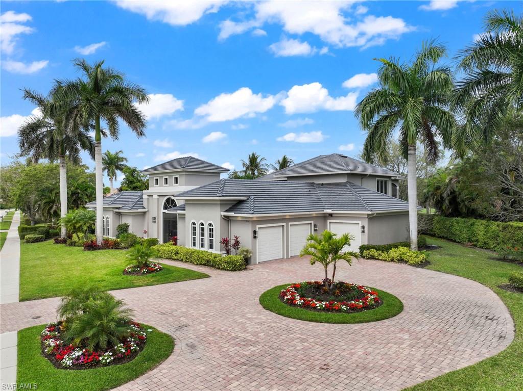 7834 Classics Drive Naples, FL 34113 - Photo 2 of 50 a front view of a house with a garden and swimming pool