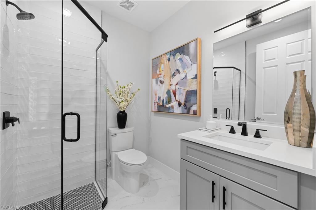 7834 Classics Drive Naples, FL 34113 - Photo 23 of 50 a bathroom with a toilet sink and shower