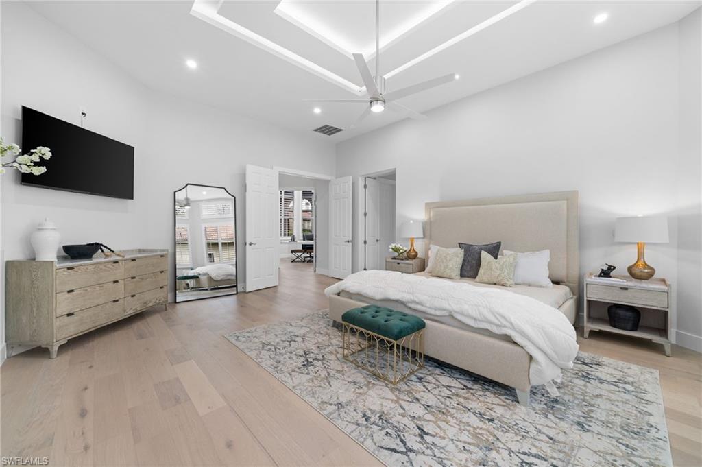 7834 Classics Drive Naples, FL 34113 - Photo 26 of 50 a spacious bedroom with a bed a flat screen tv and dresser