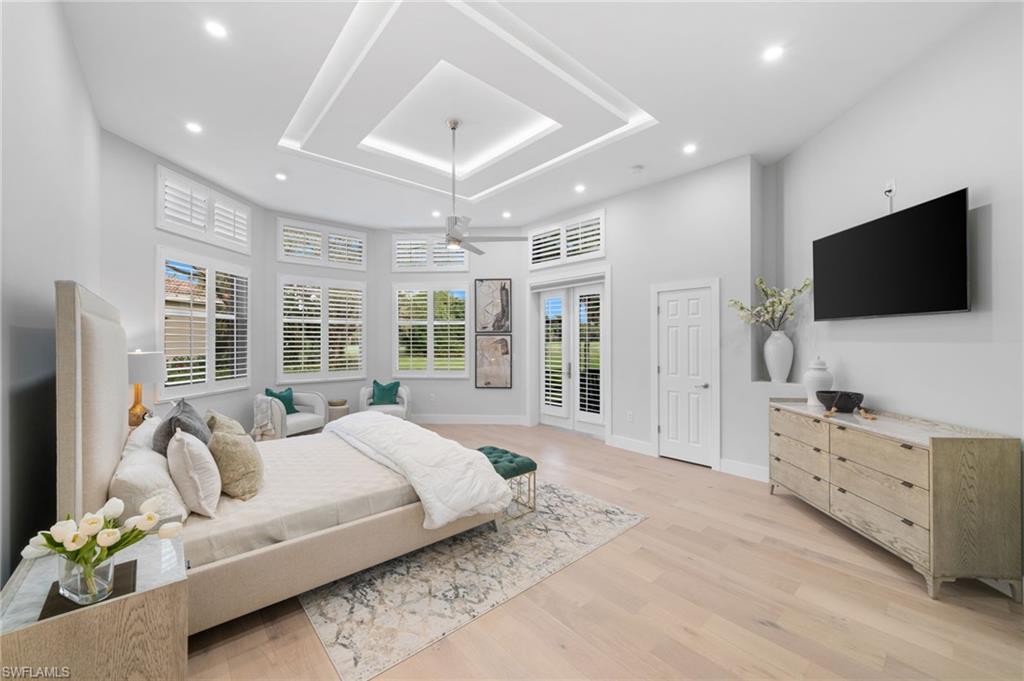 7834 Classics Drive Naples, FL 34113 - Photo 27 of 50 a spacious bedroom with a bed and a flat screen tv