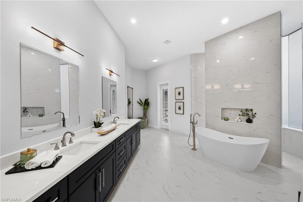 7834 Classics Drive Naples, FL 34113 - Photo 29 of 50 a spacious bathroom with a double vanity sink double mirror and bathtub