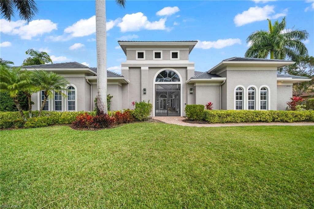 7834 Classics Drive Naples, FL 34113 - Photo 3 of 50 a front view of a house with a yard