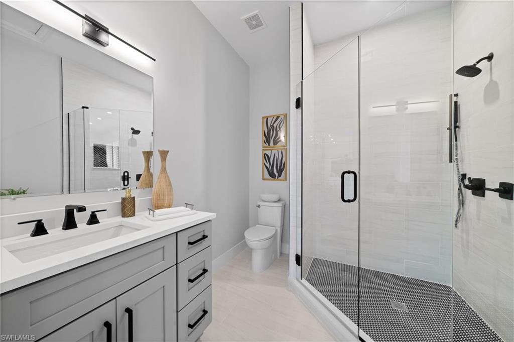 7834 Classics Drive Naples, FL 34113 - Photo 35 of 50 a bathroom with a double vanity sink mirror and toilet