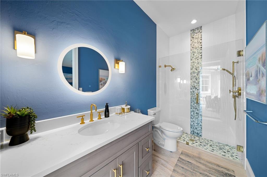 7834 Classics Drive Naples, FL 34113 - Photo 43 of 50 a bathroom with a sink a toilet and a mirror