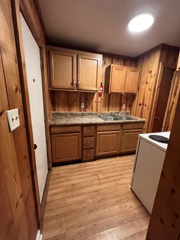 a kitchen with stainless steel appliances granite countertop a stove a sink and a refrigerator with wooden floors