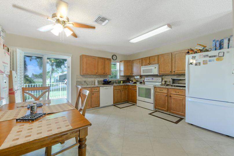 5547 3rd Road Lake Worth, FL 33467 - Photo 10 of 34 a kitchen with white cabinets and white appliances