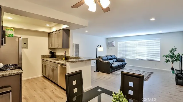 a kitchen with stainless steel appliances kitchen island granite countertop a stove a sink a refrigerator and a refrigerator