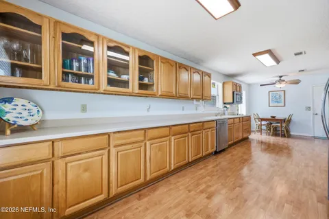 a kitchen with stainless steel appliances granite countertop a stove a sink dishwasher and a refrigerator with wooden floor