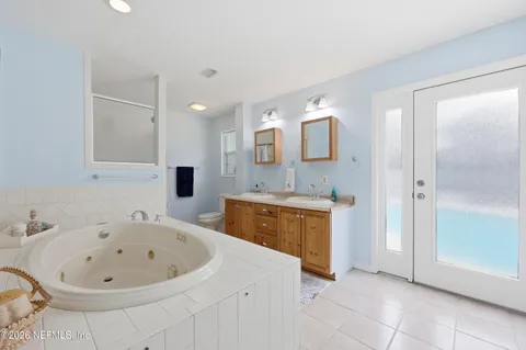 a bathroom with a tub a sink and a mirror