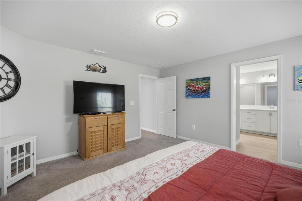 4611 Southeast 89th Street Ocala, FL 34480 - Photo 14 of 33 a bedroom with a bed and a flat screen tv