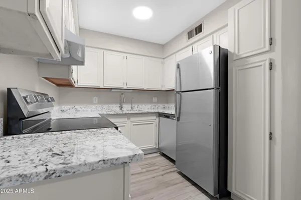 a kitchen with a refrigerator sink and cabinets