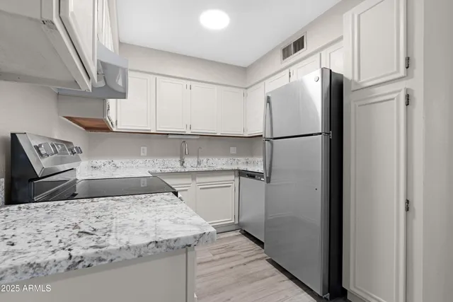 a kitchen with a refrigerator sink and cabinets