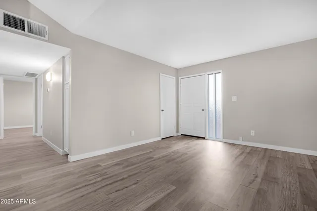 a view of an empty room with wooden floor
