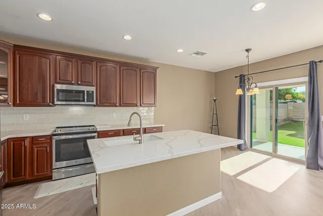 a kitchen with stainless steel appliances granite countertop refrigerator sink and cabinets
