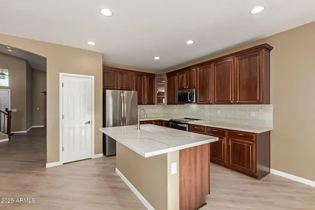 a kitchen with stainless steel appliances granite countertop a stove a refrigerator a sink and dishwasher