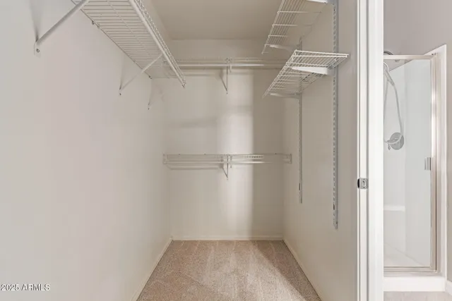 an empty room with a chandelier fan and windows