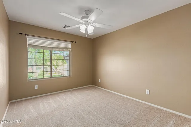 an empty room with a ceiling fan and a window