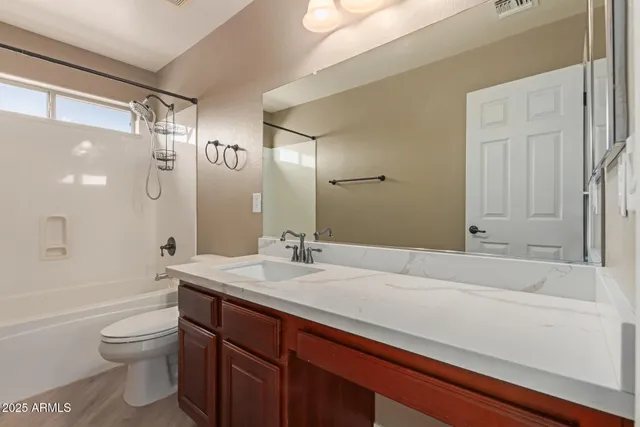a bathroom with a sink toilet vanity and shower