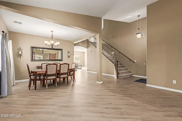 a dining room with furniture a chandelier and wooden floor
