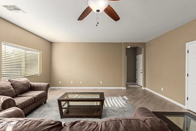 a living room with furniture and a ceiling fan
