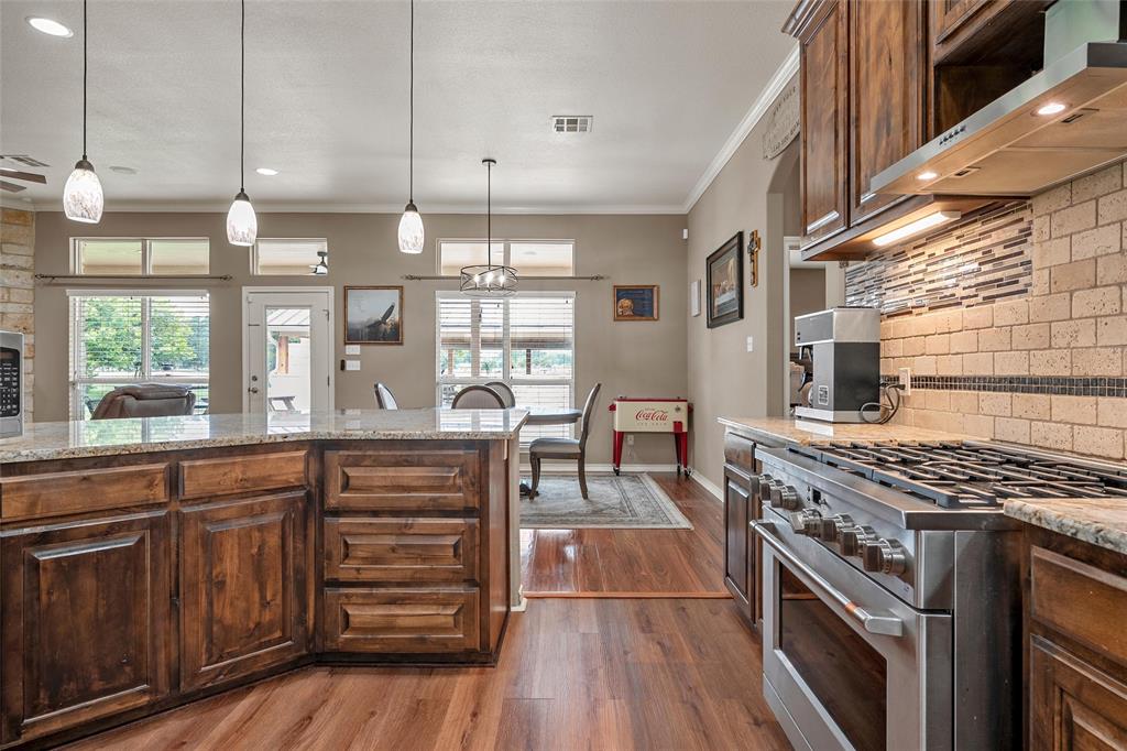 1117 Downsville Road Robinson, TX 76706 - Photo 12 of 40 Kitchen featuring wood-finish flooring, granite countertops, and rich wood cabinetry