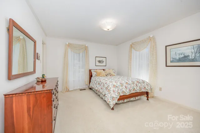 a spacious bedroom with a bed and cabinet