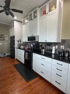 a kitchen with stainless steel appliances white cabinets and wooden floor