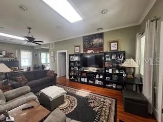 a living room with furniture a flat screen tv and a floor to ceiling window