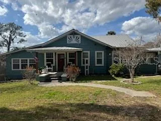 a front view of a house with swimming pool and porch with furniture