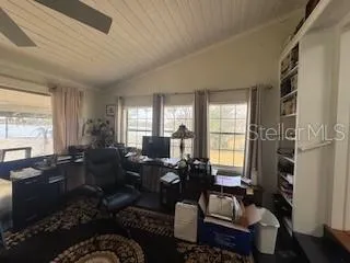 a living room with furniture fireplace and large windows