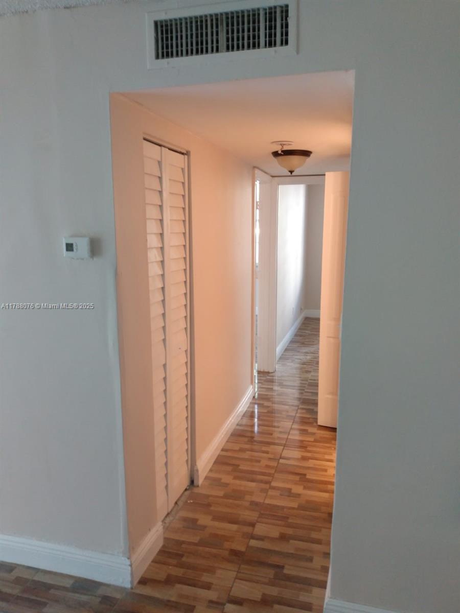 494 Northwest 165th Street, Unit C102 Miami, FL 33169 - Photo 5 of 14 a view of a hallway with wooden floor and staircase