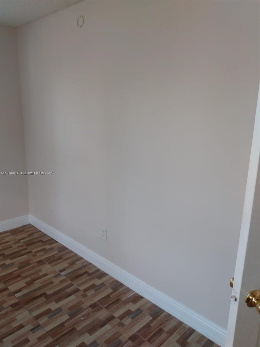 494 Northwest 165th Street, Unit C102 Miami, FL 33169 - Photo 7 of 14 a view of an empty room with wooden floor