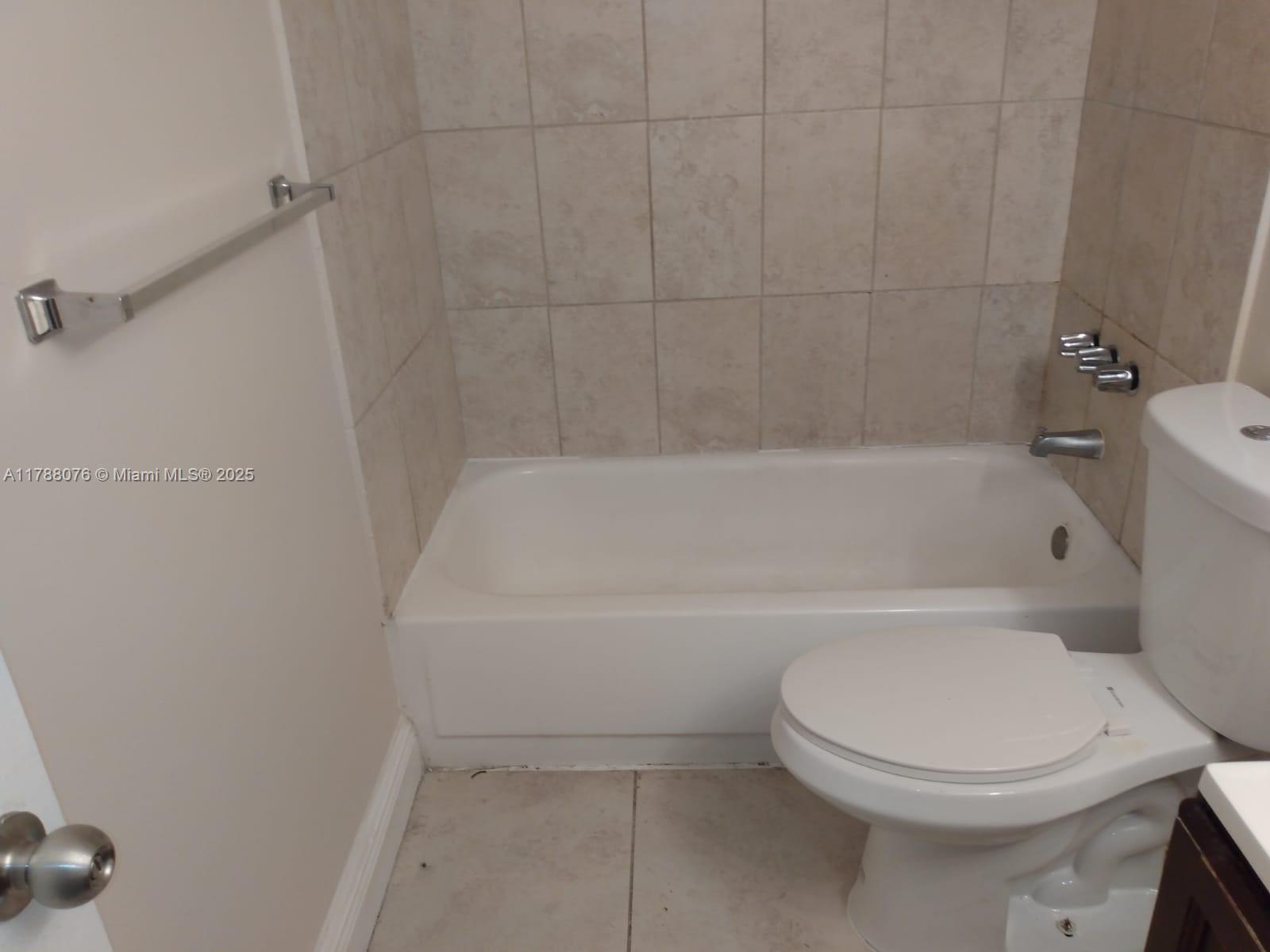 494 Northwest 165th Street, Unit C102 Miami, FL 33169 - Photo 8 of 14 a white toilet sitting next to a bath tub