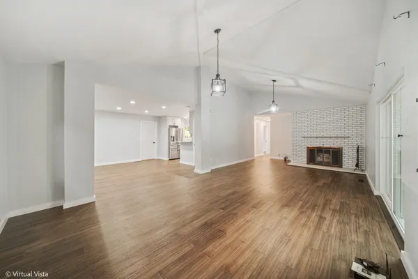 a view of empty room with wooden floor and fireplace
