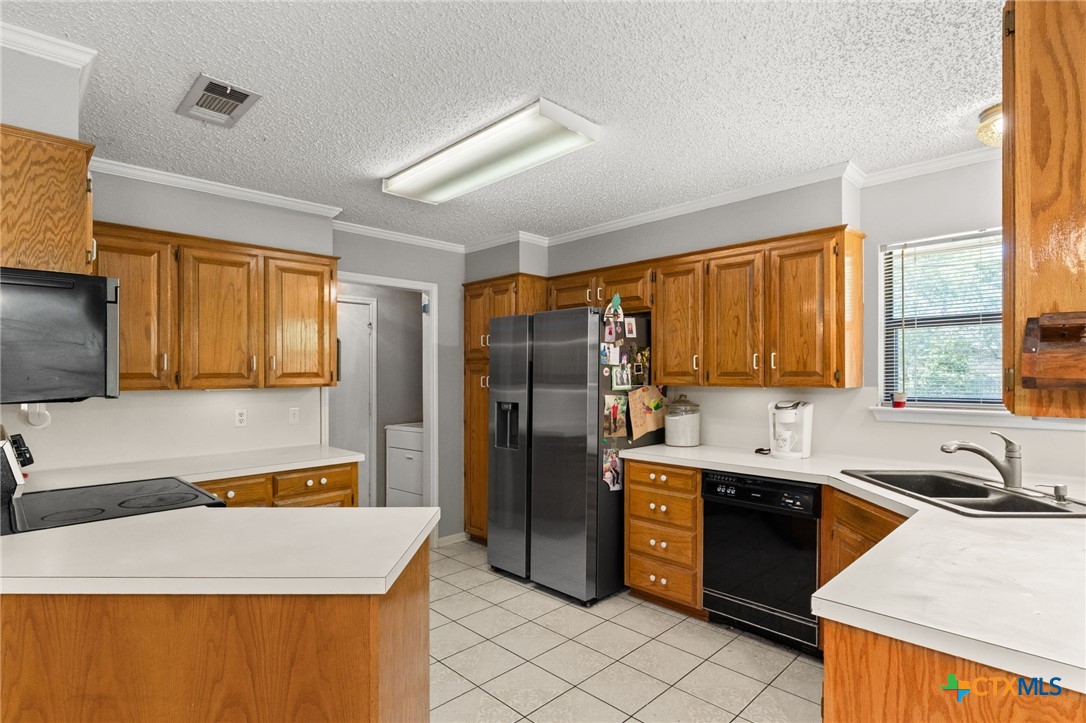 2187 Stagecoach Road Killeen, TX 76542 - Photo 8 of 27 a kitchen with stainless steel appliances granite countertop a sink and a refrigerator