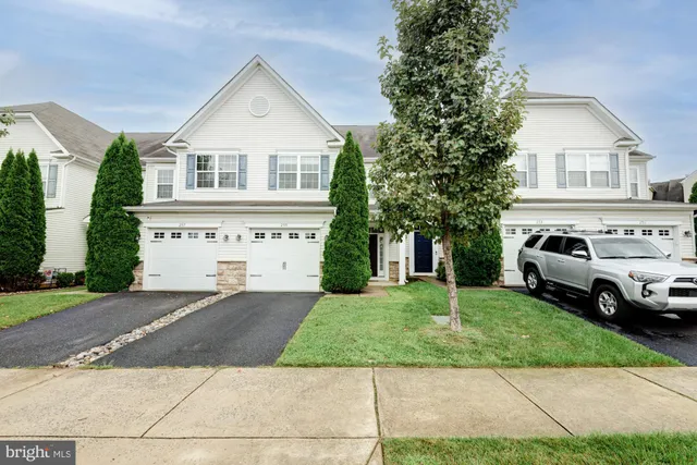 a white house that has a tree in front of it