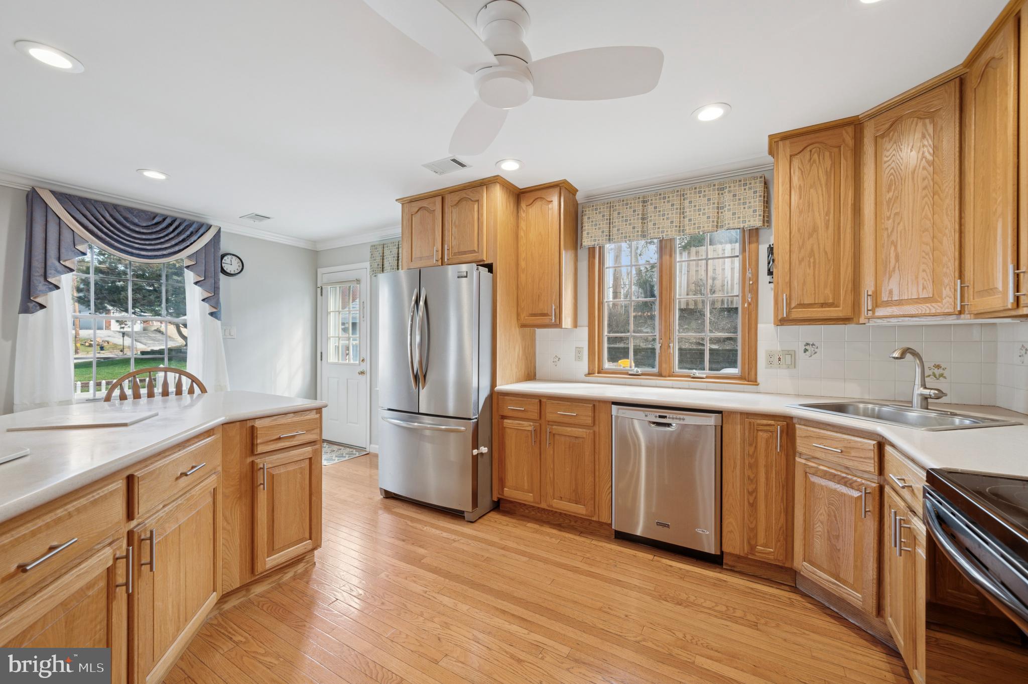 946 Georgetown Road Swarthmore, PA 19081 - Photo 16 of 36 a kitchen with stainless steel appliances granite countertop a refrigerator a sink dishwasher a stove and white countertops with wooden floor
