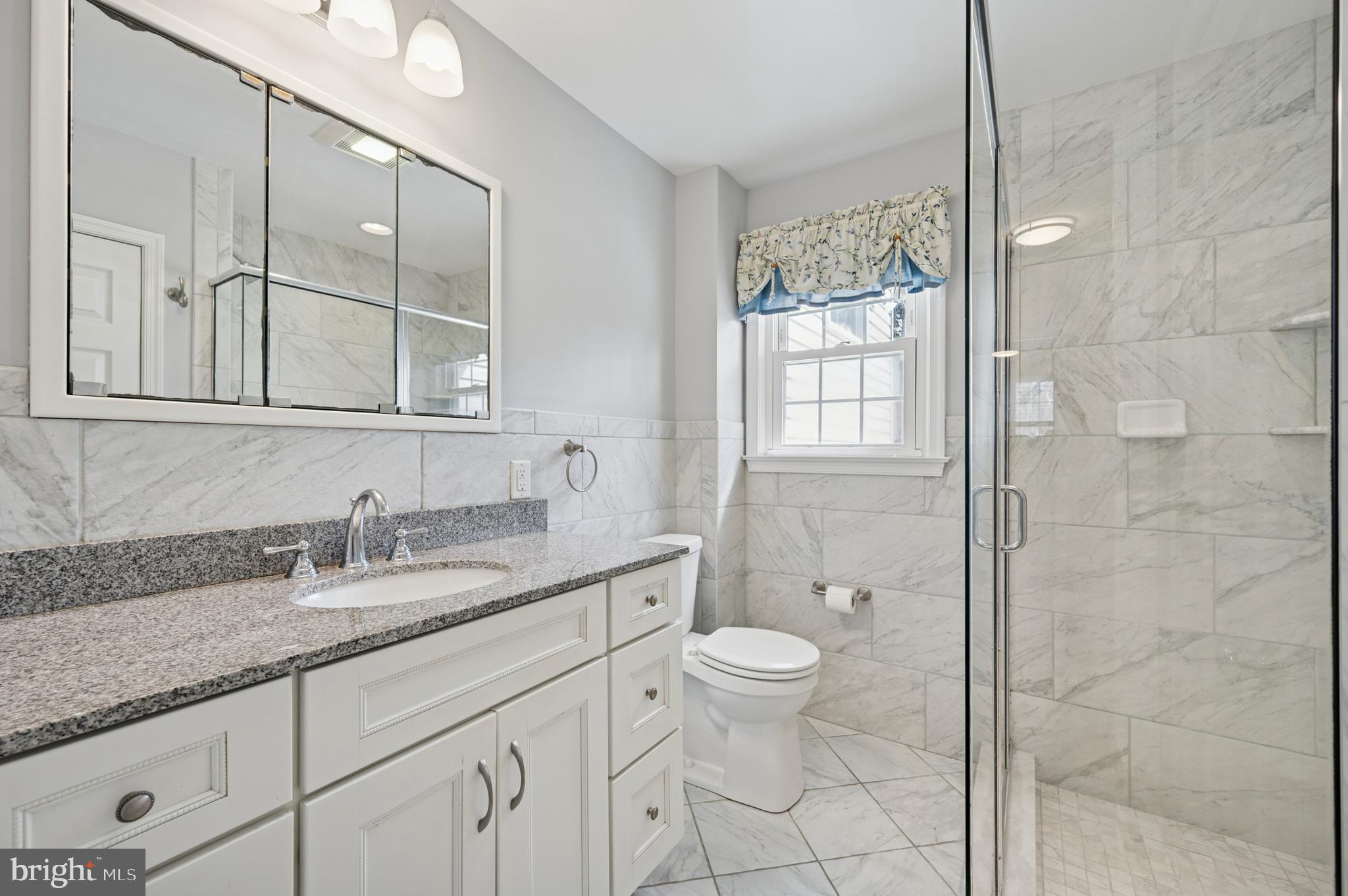 946 Georgetown Road Swarthmore, PA 19081 - Photo 32 of 36 a bathroom with a granite countertop sink a toilet and shower