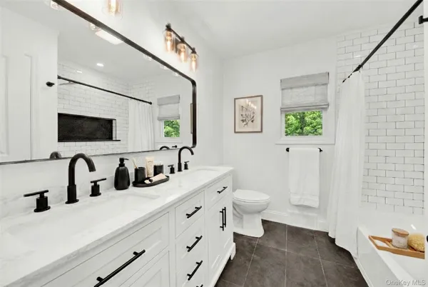 a bathroom with double sink and a mirror
