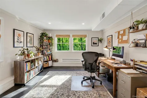 a view of a workspace with furniture and a window
