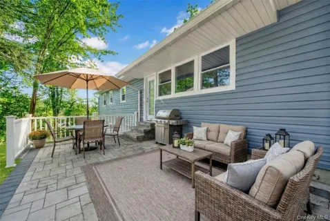 a view of a patio with a table and chairs under an umbrella