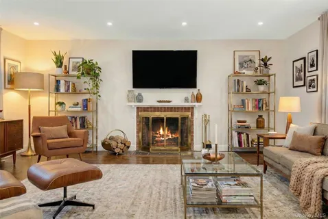 a living room with furniture a flat screen tv and a fireplace