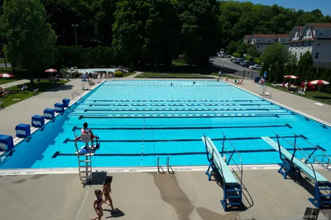 a view of a tennis ground with large trees