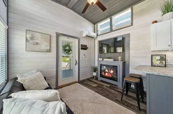 a living room with furniture a fireplace and a flat screen tv