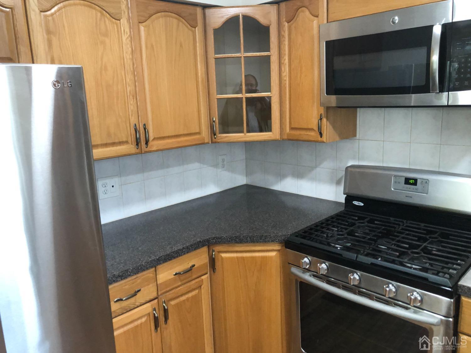 420 Cross Road, Unit B11 Matawan, NJ 07747 - Photo 3 of 9 a kitchen with a stove and a microwave
