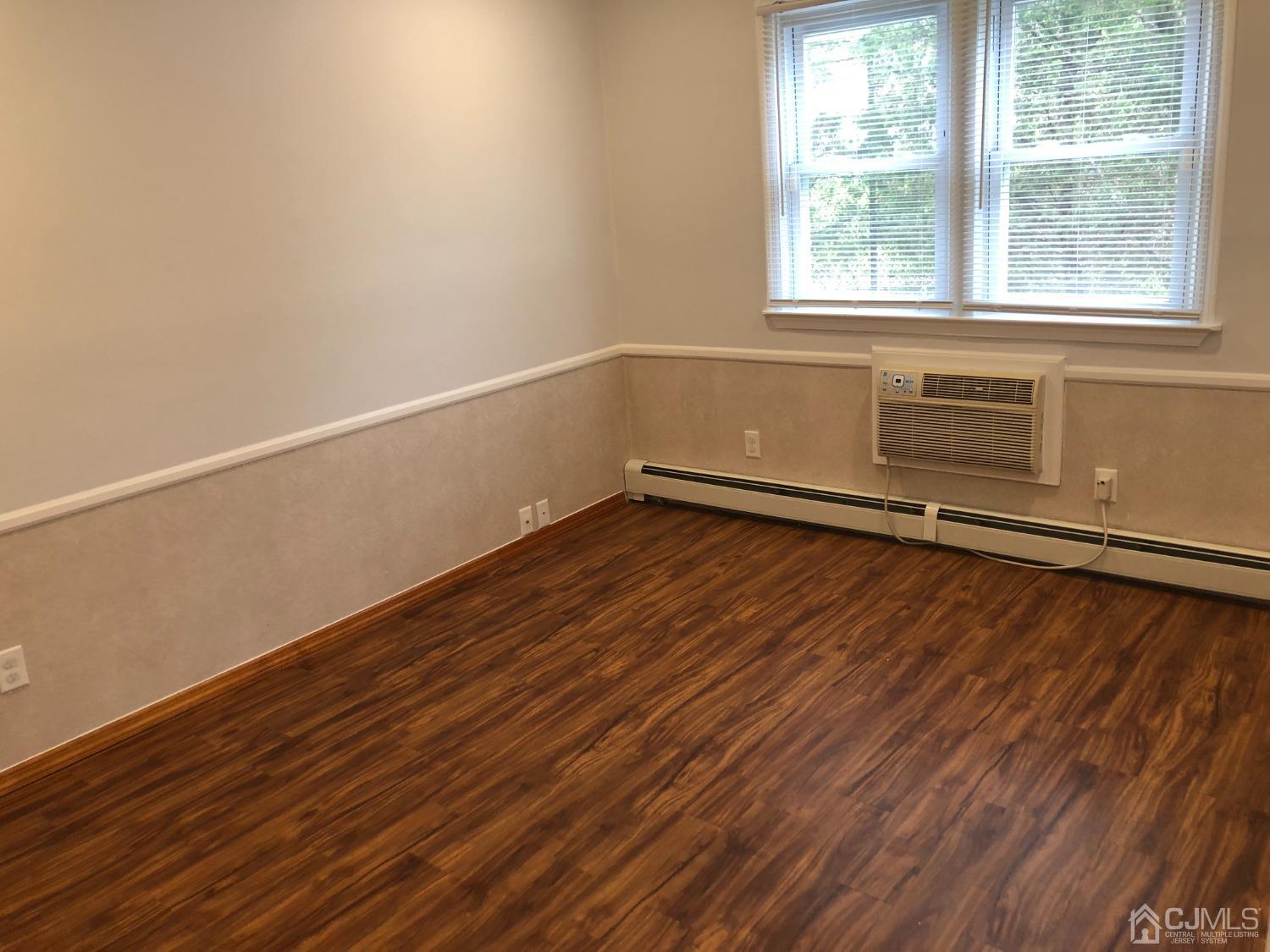 420 Cross Road, Unit B11 Matawan, NJ 07747 - Photo 5 of 9 an empty room with wooden floor and windows